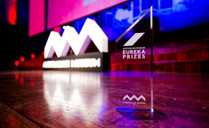 Image: Eureka Prizes A trophy on a stage in front of a large screen and statue